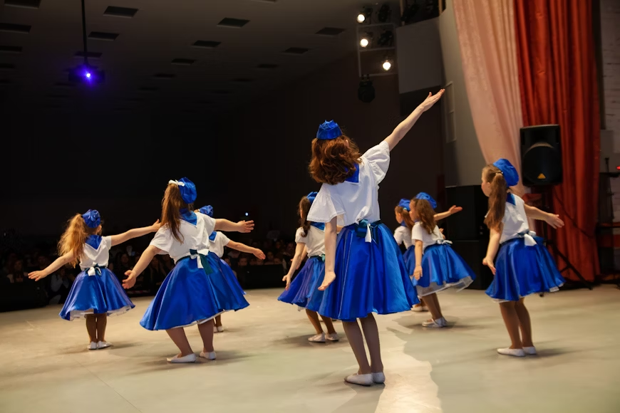 Kids in T3 Triple Threat youth acting program rehearsing on stage.